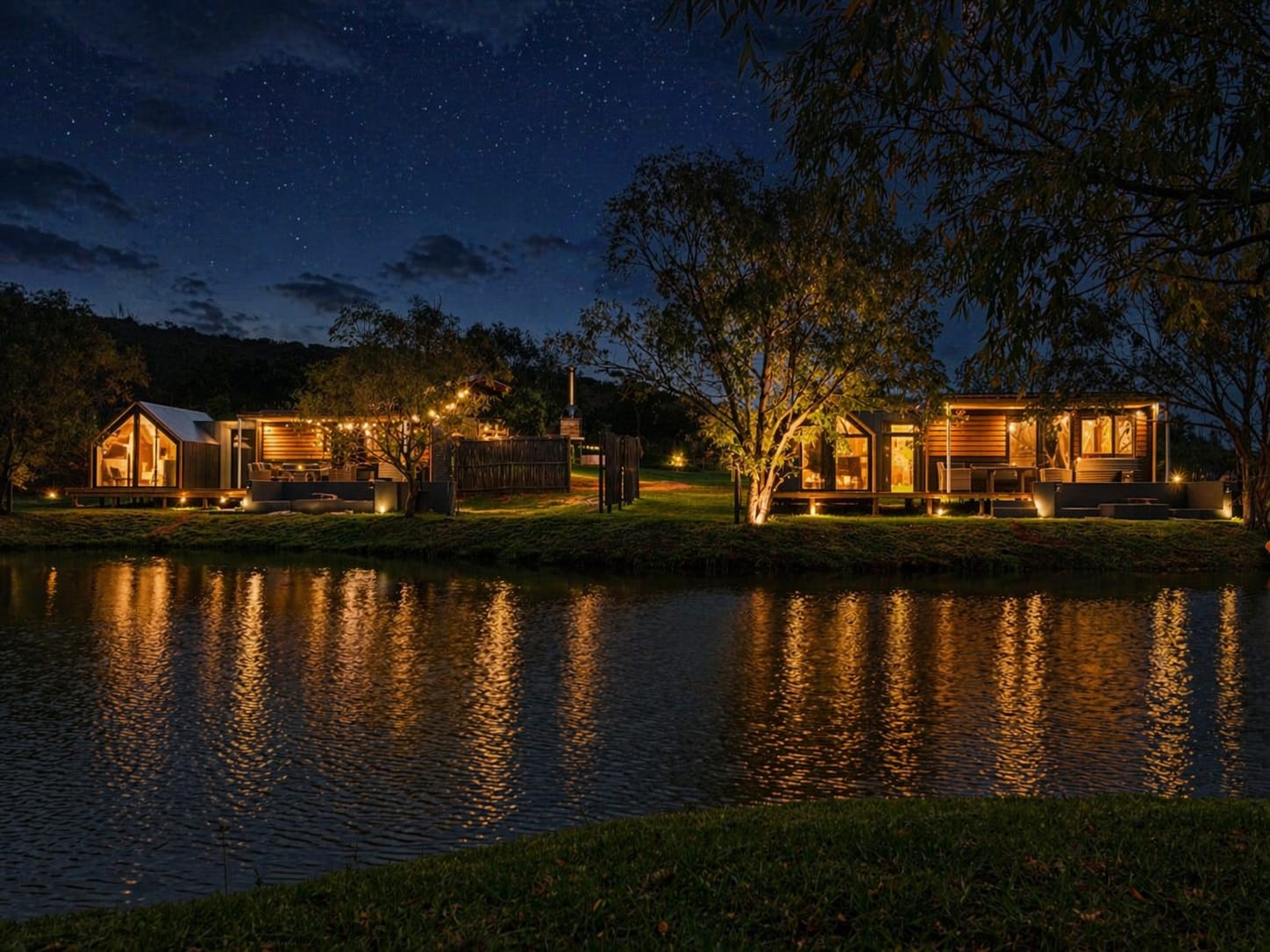 Evening view of lit-up cabins at Kam'Bati creating a warm glow against the night landscape. Night View of Cabins at Kam'Bati